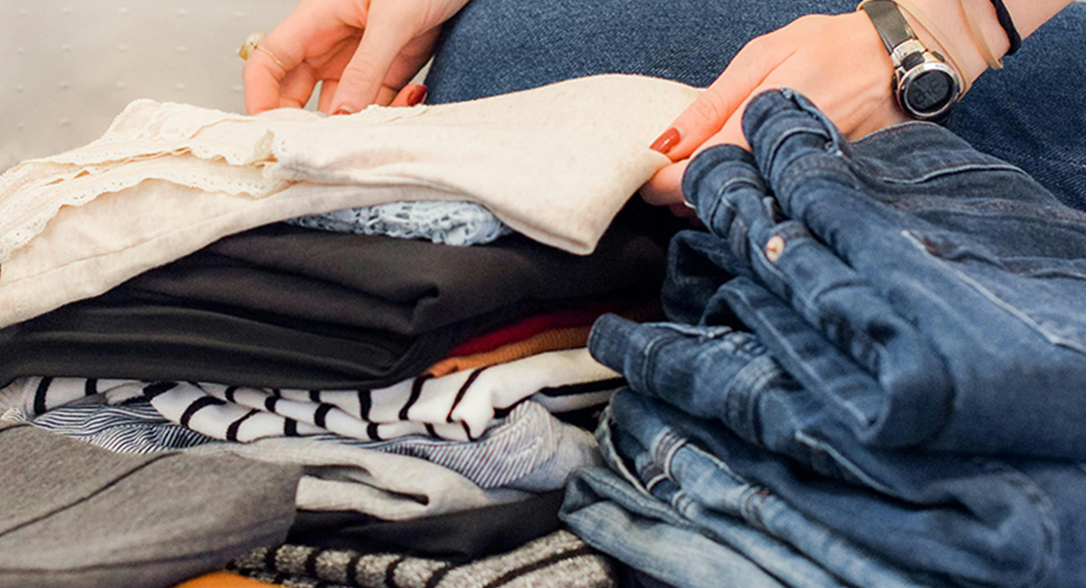 a woman folding clothes on the floor while decluttering your home